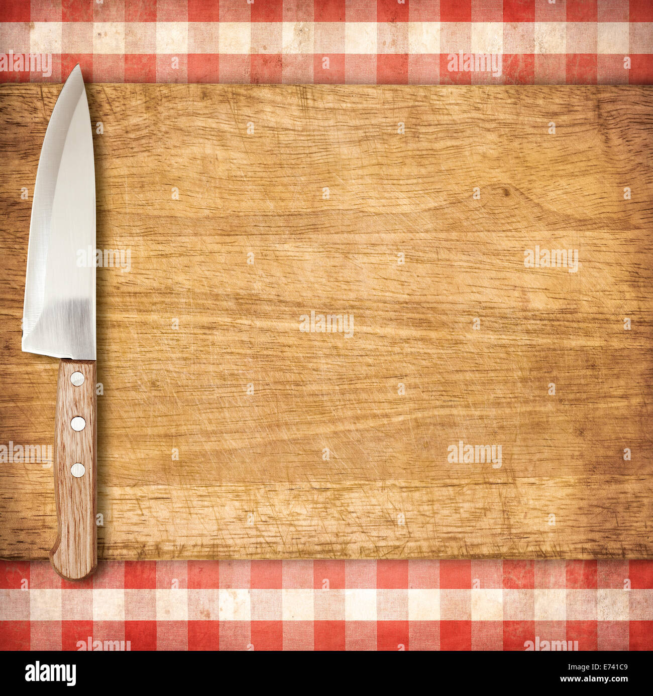 Steckbrett schneiden und Messer über rote Grunge karierte Tischdecke Hintergrund Stockfoto