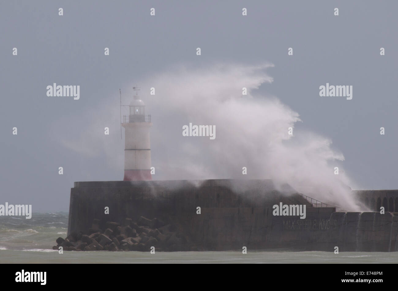 Winterwellen, die über den Leuchtturm am Eingang zum Hafen von Newhaven Stockfoto