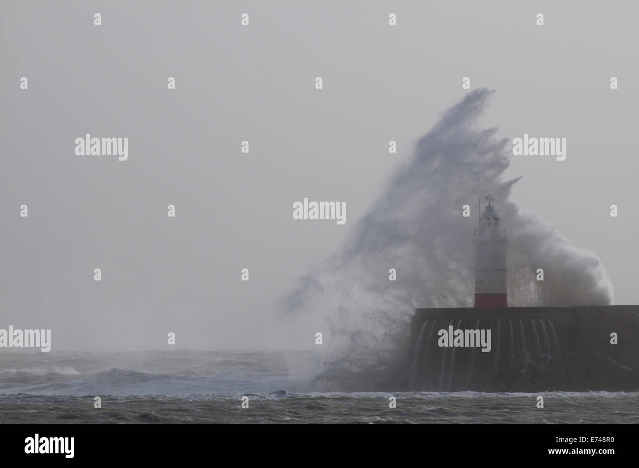 Winterwellen, die über den Leuchtturm am Eingang zum Hafen von Newhaven Stockfoto