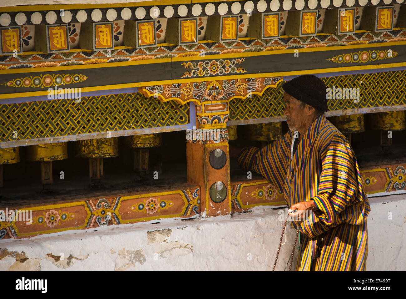 Ost Bhutan, Trashi Yangtse Chorten Kora, gekleidete traditionell Mann Gebetsmühlen drehen Stockfoto