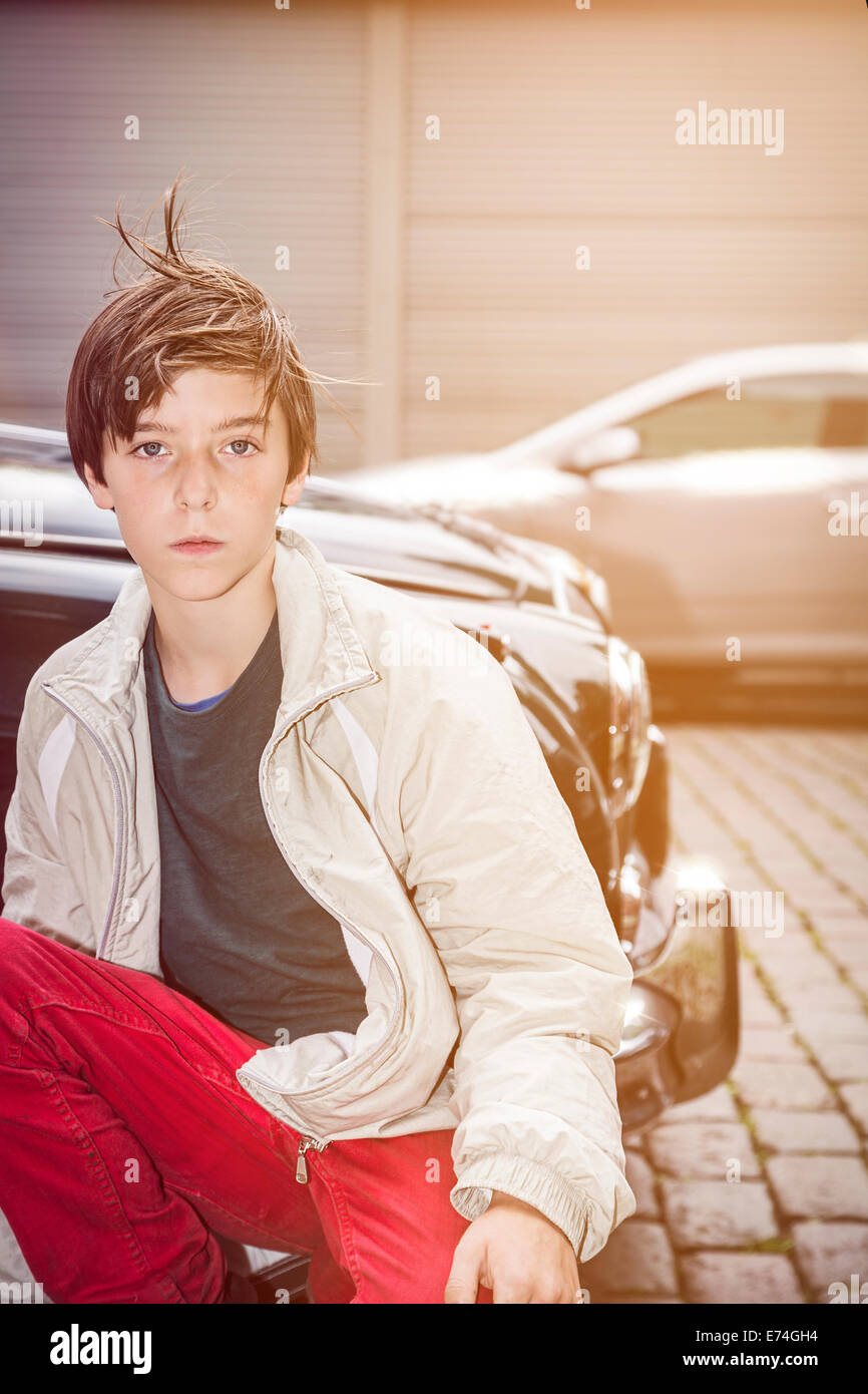 Portrait eines jungen Teenager vor einem alten teuren Auto Stockfoto