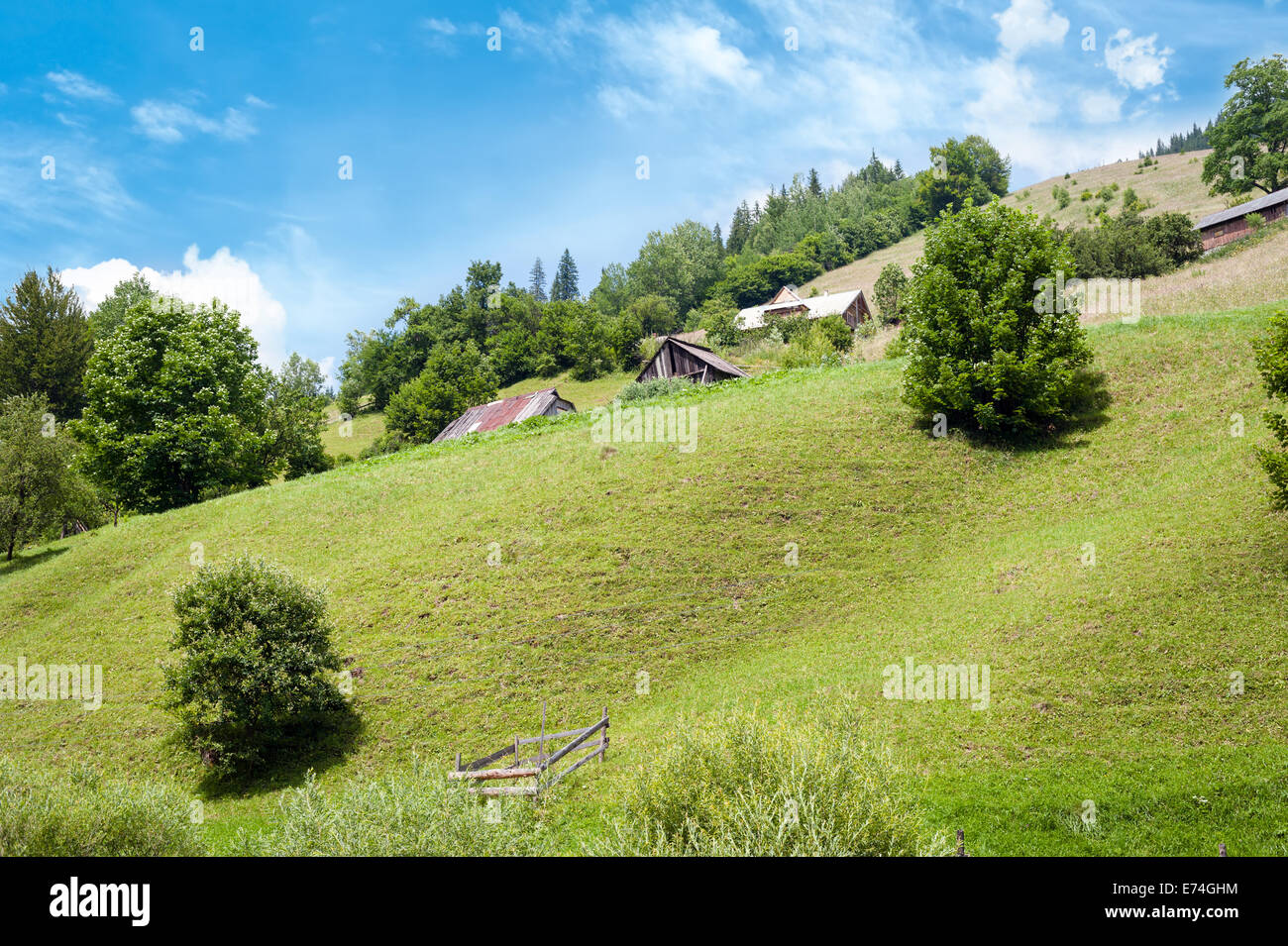 Kulturlandschaft der Karpaten. Kleines Dorf mit traditionellen Holzhäuser am sonnigen Tag unter blauem Himmel Stockfoto