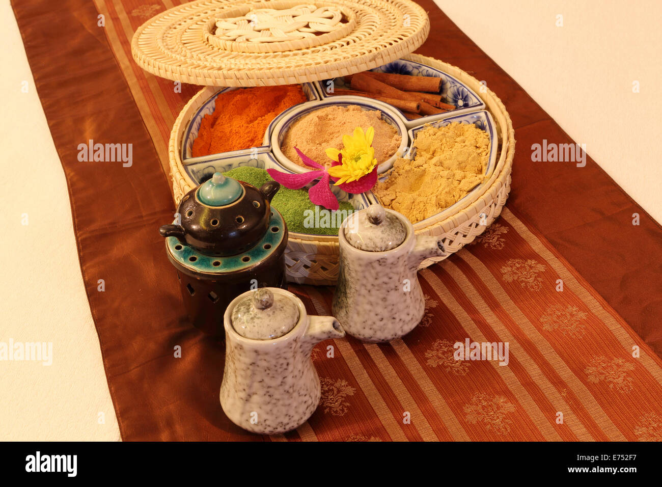Teekannen und Süd-Ost-asiatischen Gewürzen in einer gewebten Geschenkbox auf Seide. Stockfoto