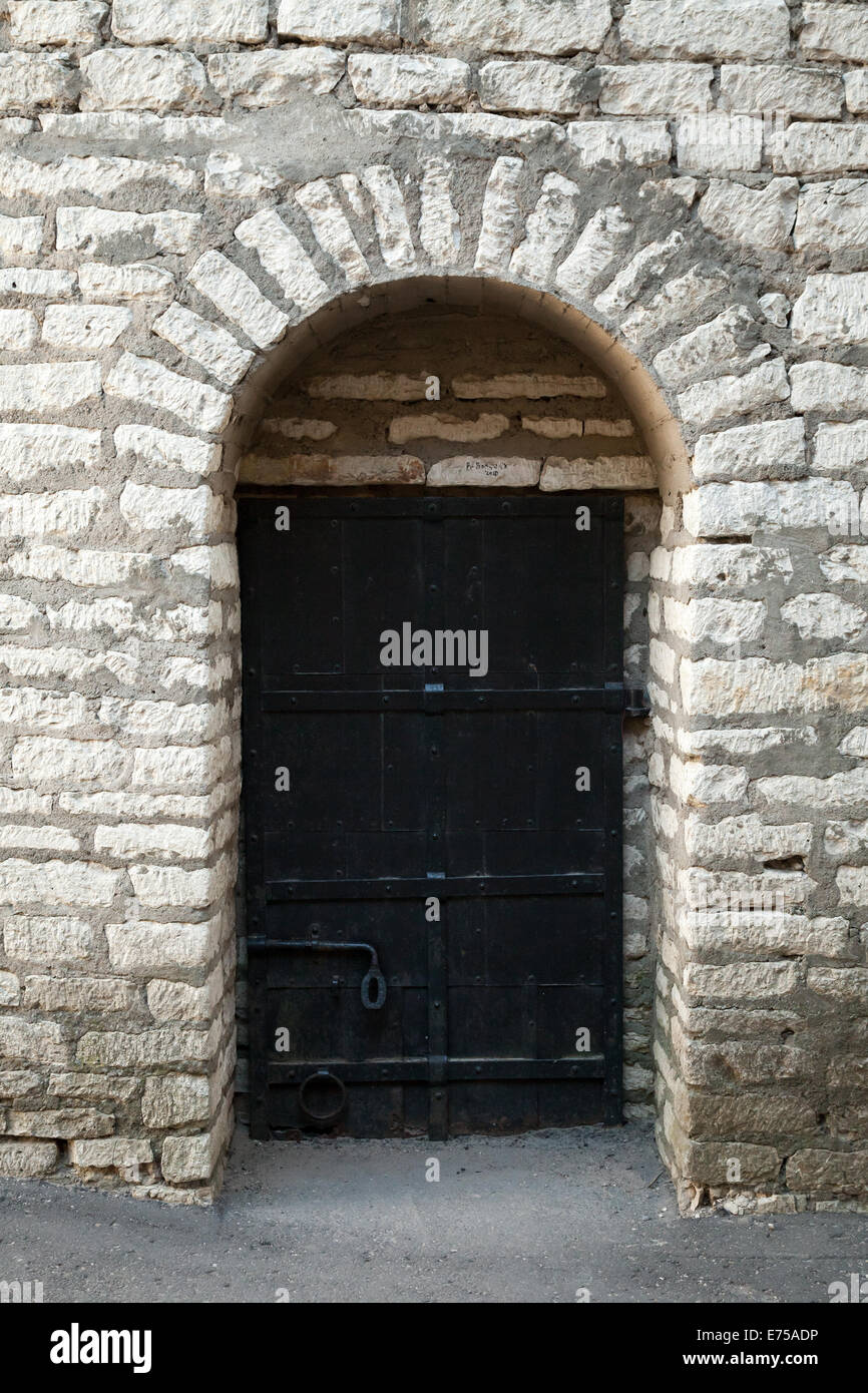 Alte Steinmauer und schwarze Metalltür, Hintergrundtextur Stockfoto