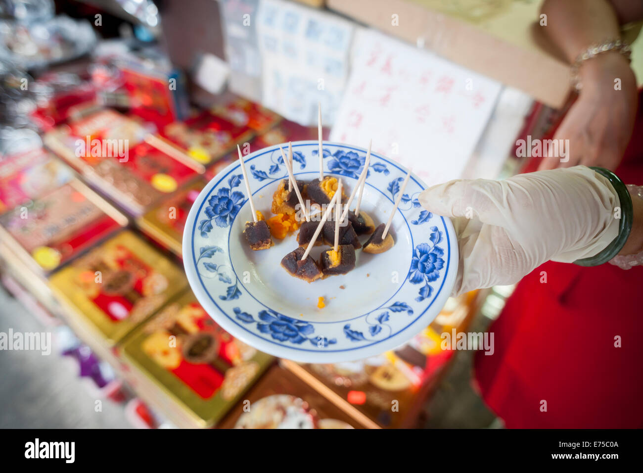 New York, USA. 7. September 2014. Ein Geschäft in Chinatown in New York bieten Proben von ihren des Mooncakes auf Sonntag, 7. September 2014 für das Mid-Autumn Festival, das am 8. September auftritt. Die leckeren gebackenen Traditionsprodukt wird während des Mid-Autumn Festival gegessen und sind beliebt als Geschenk. Die perfekt runde Gebäck können süß oder herzhaft, gefüllt mit Lotus Samen oder gesalzen Entenei. Die Kuchen sind der Vollmond auf dem achten Monat, am fünfzehnten Tag im chinesischen (Mondkalender). Bildnachweis: Richard Levine/Alamy Live-Nachrichten Stockfoto