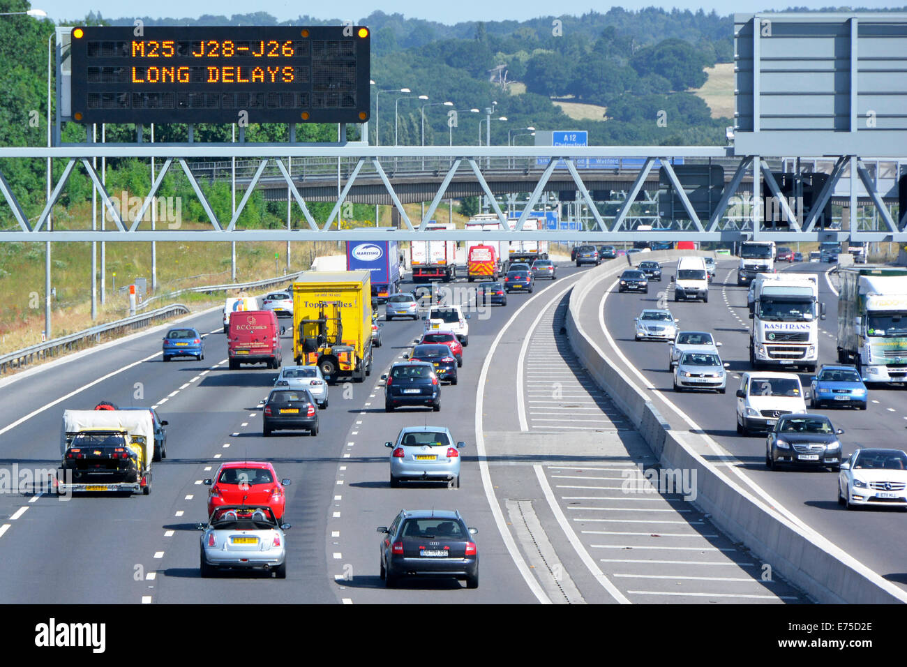 Autobahnverkehr & digitale elektronische Technologie Straßenschild mit Vorwarnung lange Verzögerungen im Uhrzeigersinn M25 Route nächste Kreuzung 28 Brentwood UK Stockfoto