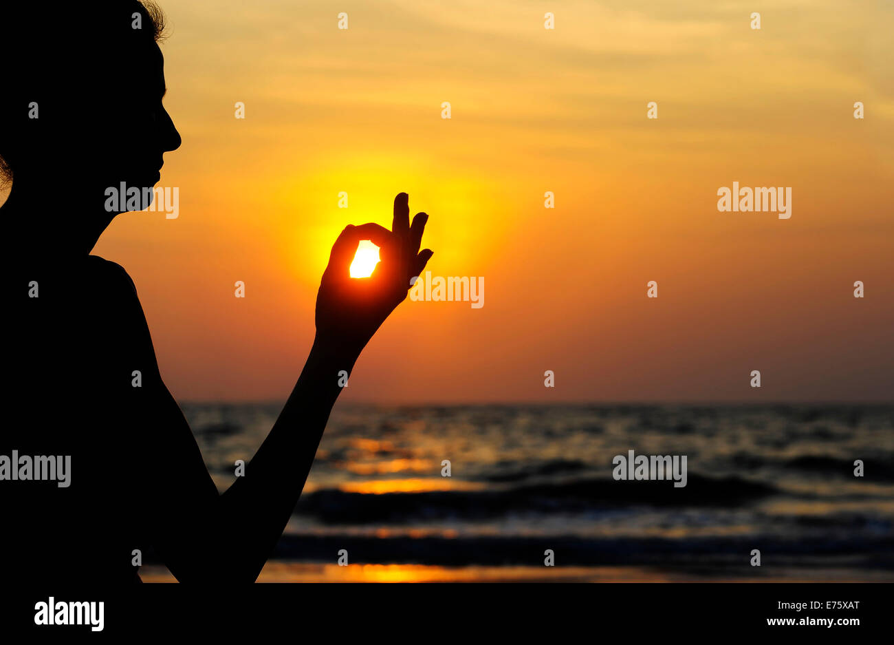 Frau, meditieren am Strand bei Sonnenuntergang, Kerala, Indien Stockfoto