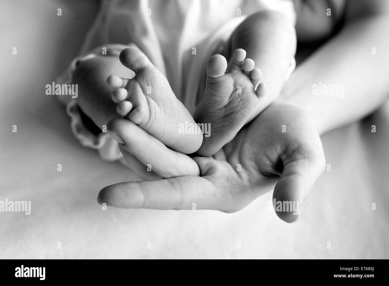 Übergeordneten Hand halten Baby Mädchen Beine Stockfoto