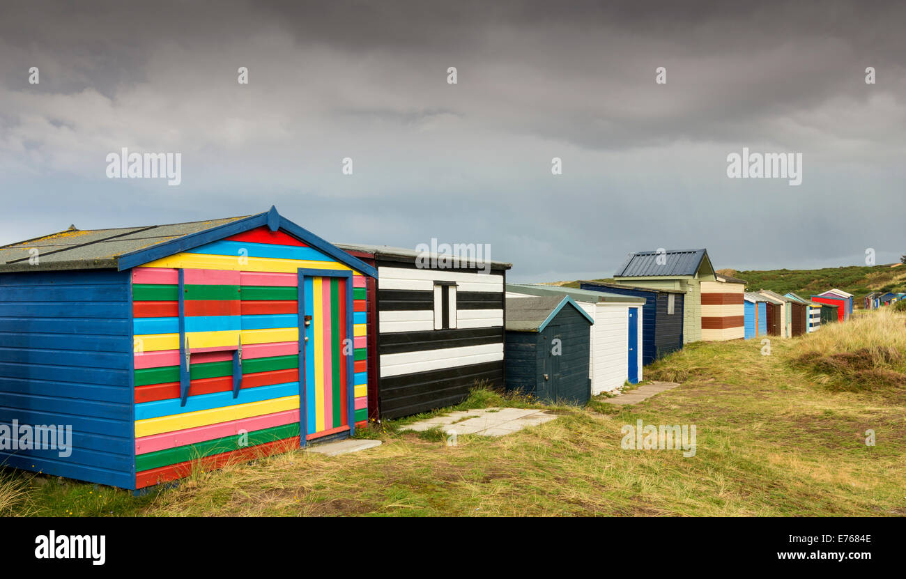 CHALETS AM STRAND HOPEMAN MORAY REGENWOLKEN VORBEI ÜBER DIE REIHEN DER MULTI FARBIGE HÜTTEN Stockfoto