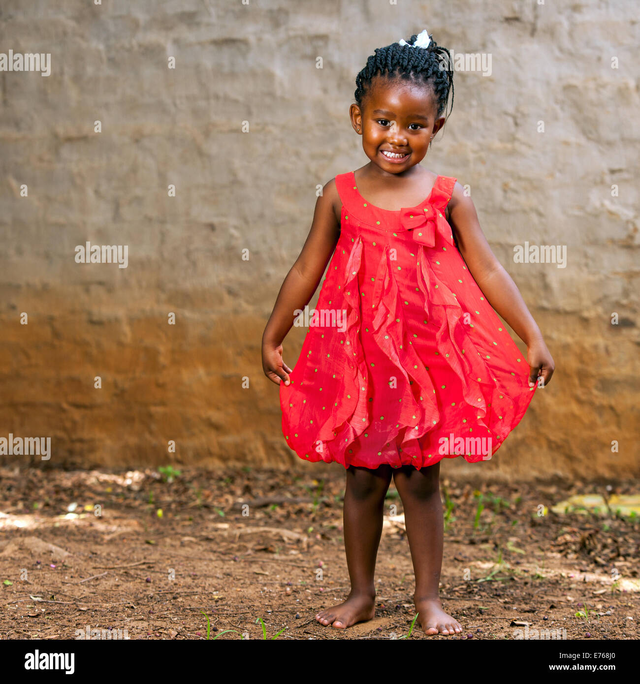 In voller Länge Portrait von niedlichen afrikanischen Mädchen zeigen rote Kleid im Freien. Stockfoto