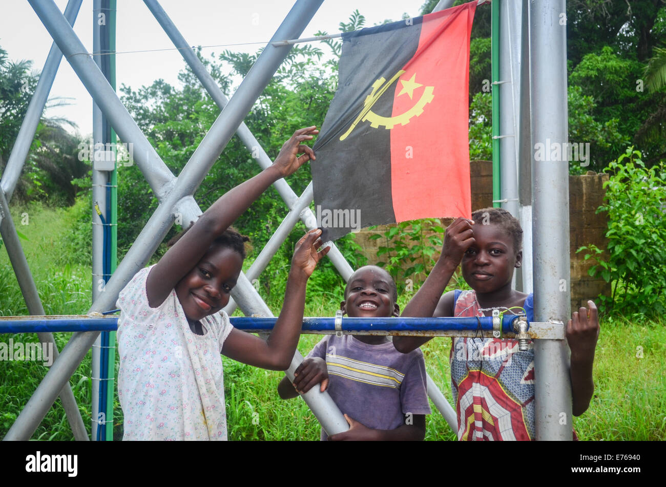 Lächelnde angolanischen Kinder posieren mit der Flagge Angolas Stockfoto