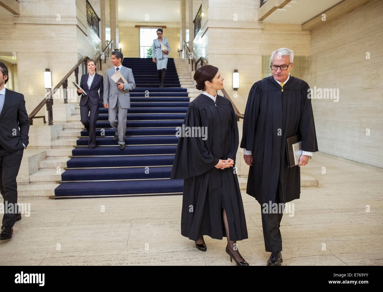Richter und Anwälte zu Fuß durch Gerichtsgebäude Stockfoto
