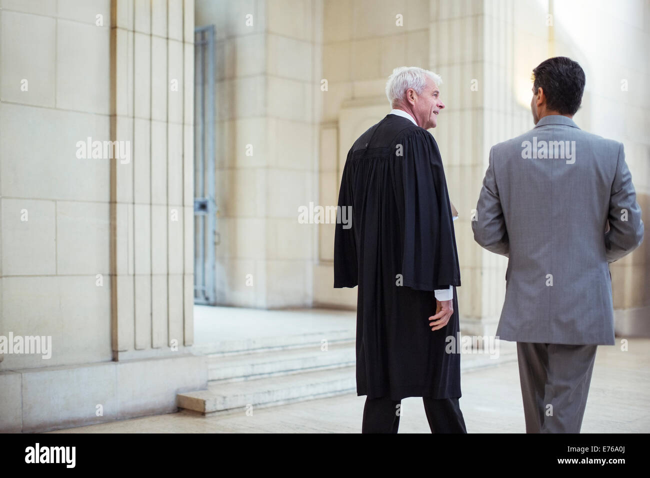 Richter und Anwalt zu Fuß durch Gerichtsgebäude zusammen Stockfoto