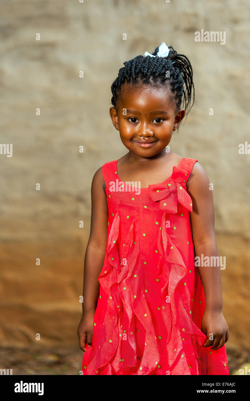 Porträt von netten afrikanischen Mädchen im roten Kleid im Freien stehen hautnah. Stockfoto