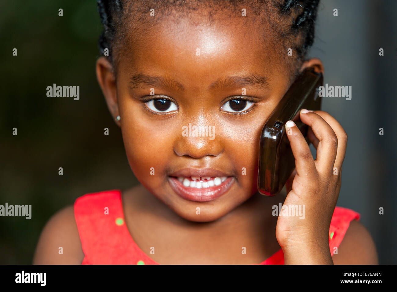 Extreme Gesichts Porträt von niedlichen afrikanischen Mädchen, das Gespräch auf Smartphone. Stockfoto