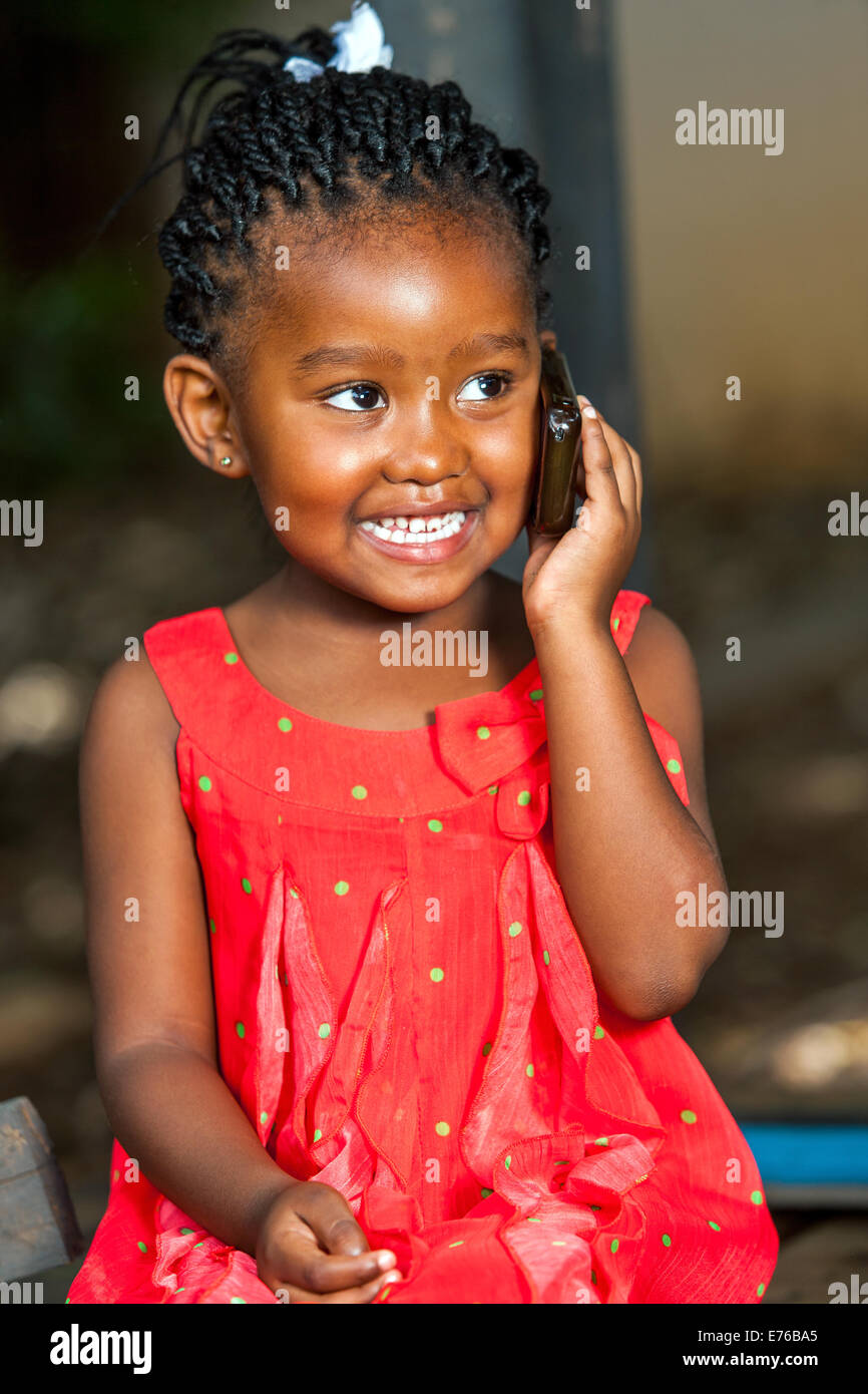 Porträt von niedlichen afrikanischen Mädchen, das Gespräch auf Smartphone im freien hautnah. Stockfoto