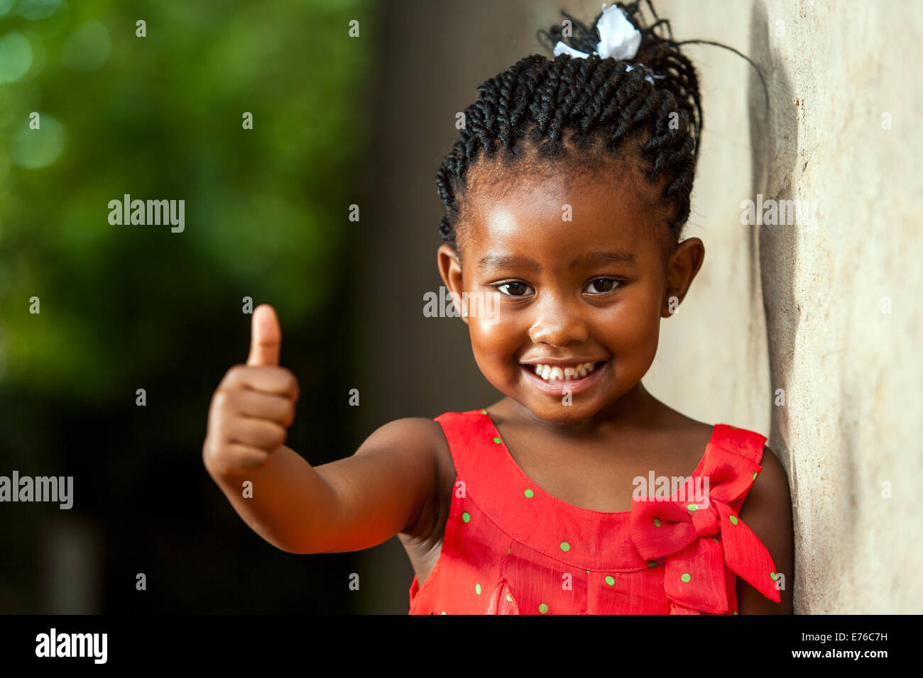 Porträt von glücklich kleine afrikanische Mädchen Daumen hoch Zeichen im Freien zu tun. Stockfoto