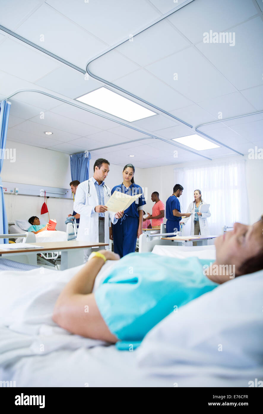 Arzt und Krankenschwester lesen medizinischen Diagramm im Krankenzimmer Stockfoto