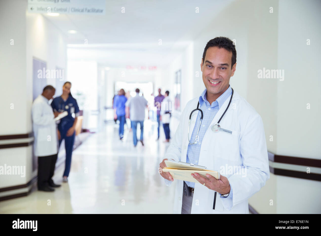 Arzt im Krankenhaus Flur lächelnd Stockfoto