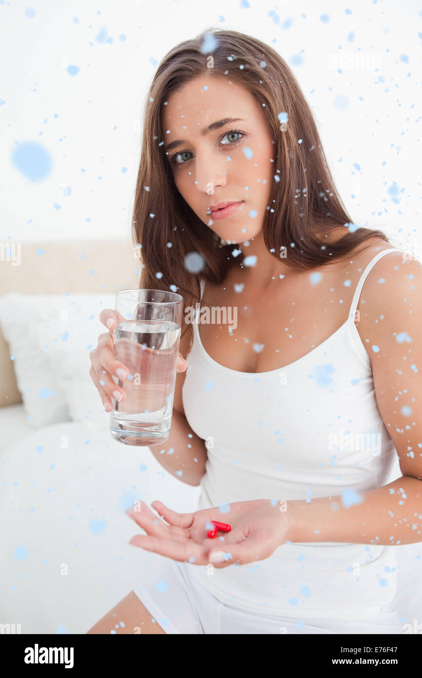 Zusammengesetztes Bild der Frau, die besorgt, da sie zwei Tabletten mit Wasser einnehmen soll, Stockfoto