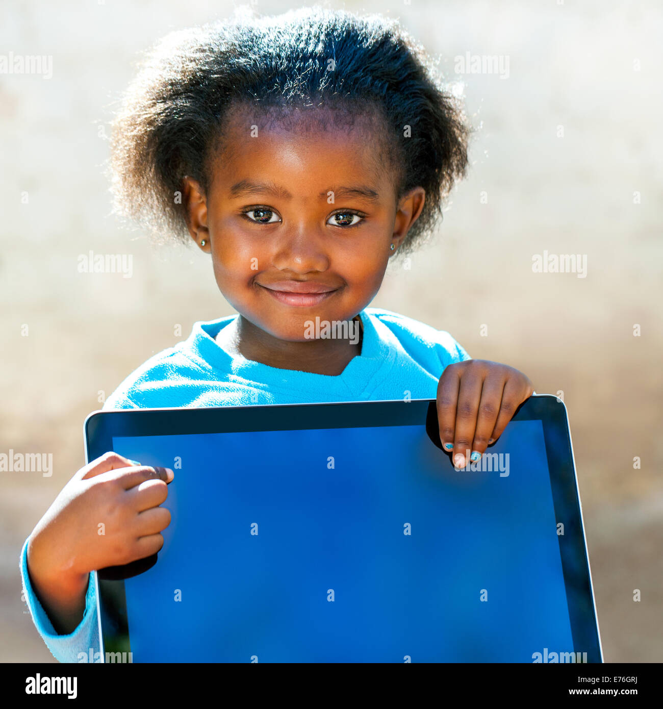 Porträt von afrikanischen Mädchen zeigt mit Finger auf leeren Computerbildschirm hautnah. Stockfoto