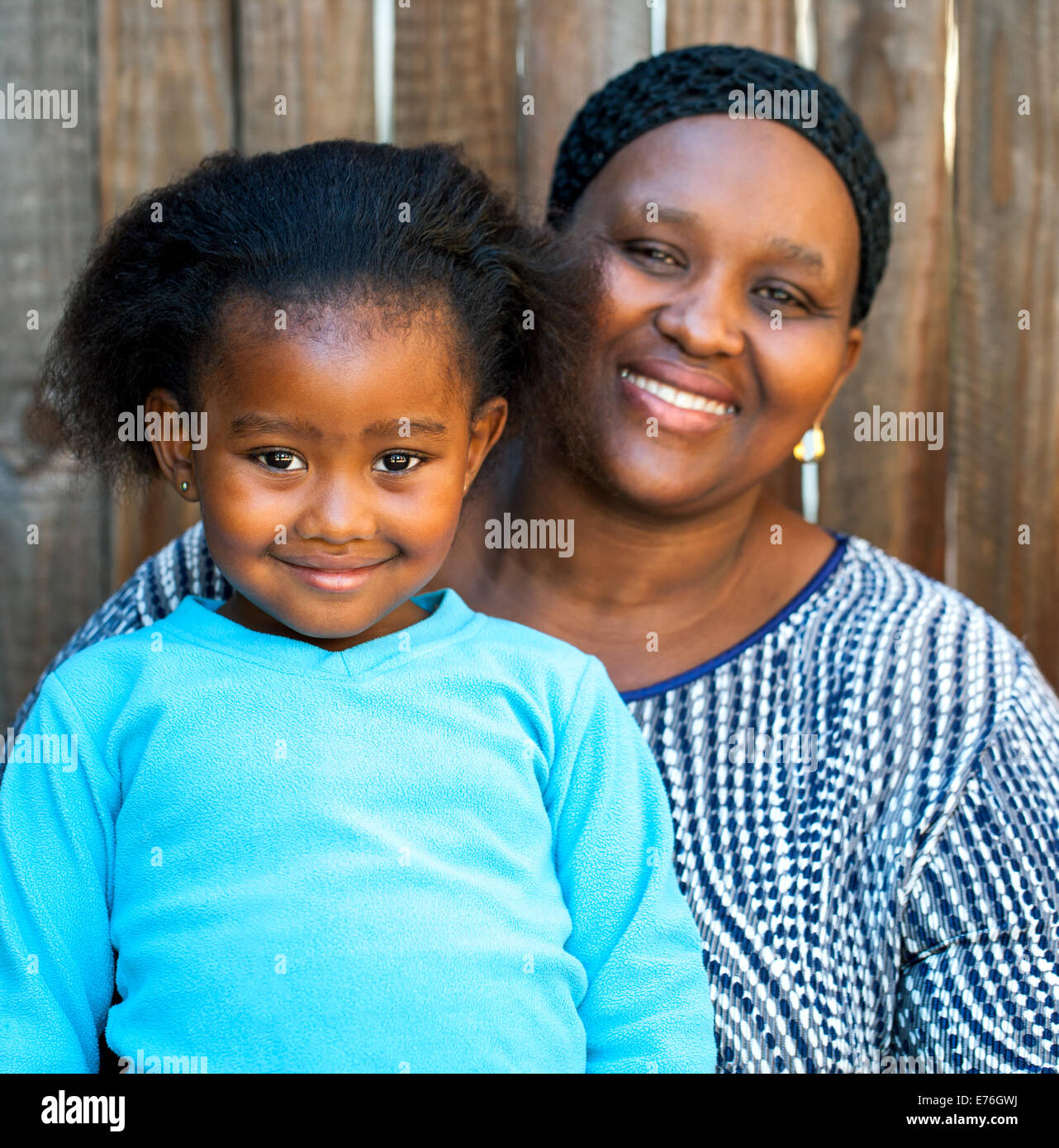 Portrait des afrikanischen Mama und Tochter gegen Holzzaun. Stockfoto
