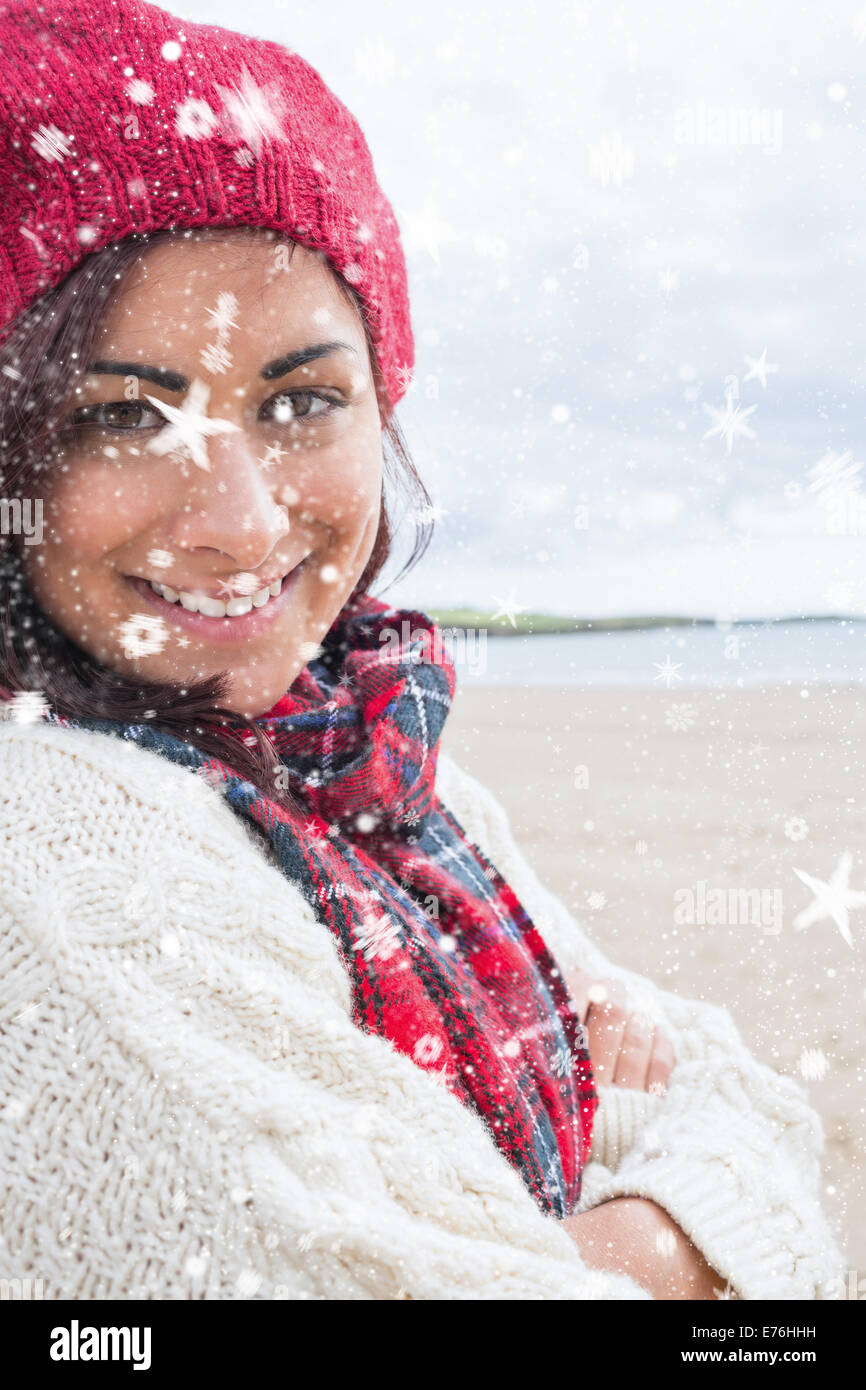Zusammengesetztes Bild der Frau in Strickmütze und Pullover lächelnd am Strand Stockfoto
