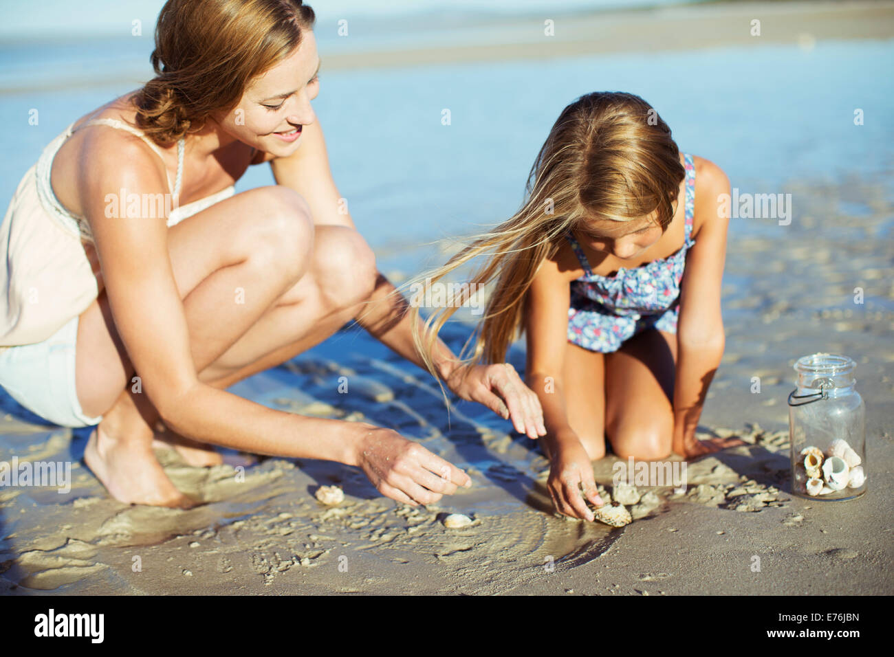 Mutter und Tochter im Sand spielen Stockfoto