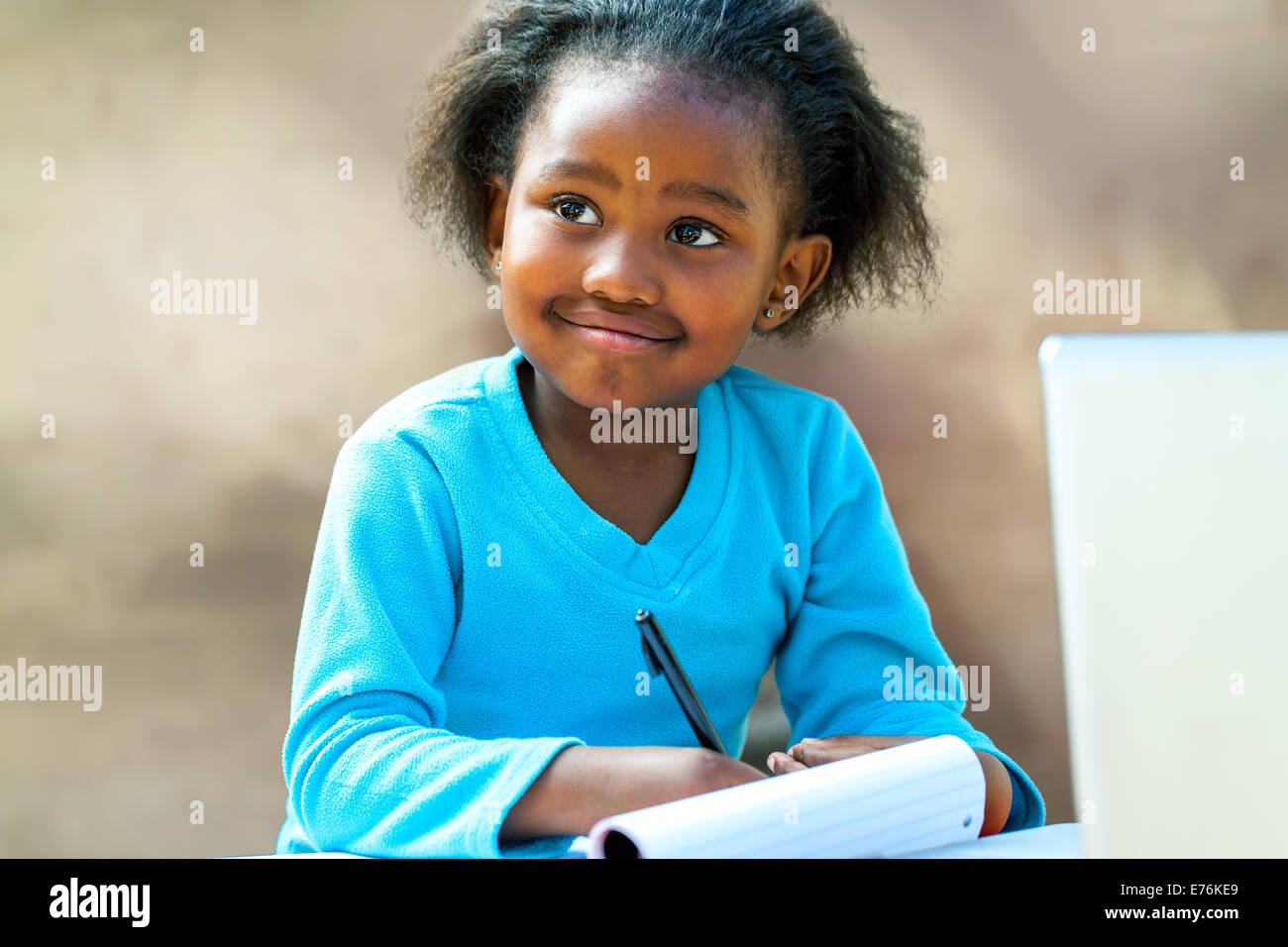 Porträt von afrikanischen Mädchen schreiben in Notebook am Schreibtisch. Stockfoto
