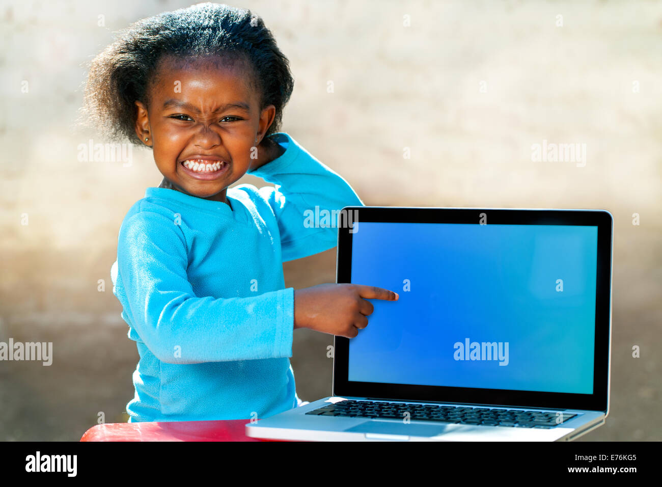 Porträt von afrikanischen Mädchen mit lustigen Gesichtsausdruck auf leeren Laptop-Bildschirm zeigen. Stockfoto