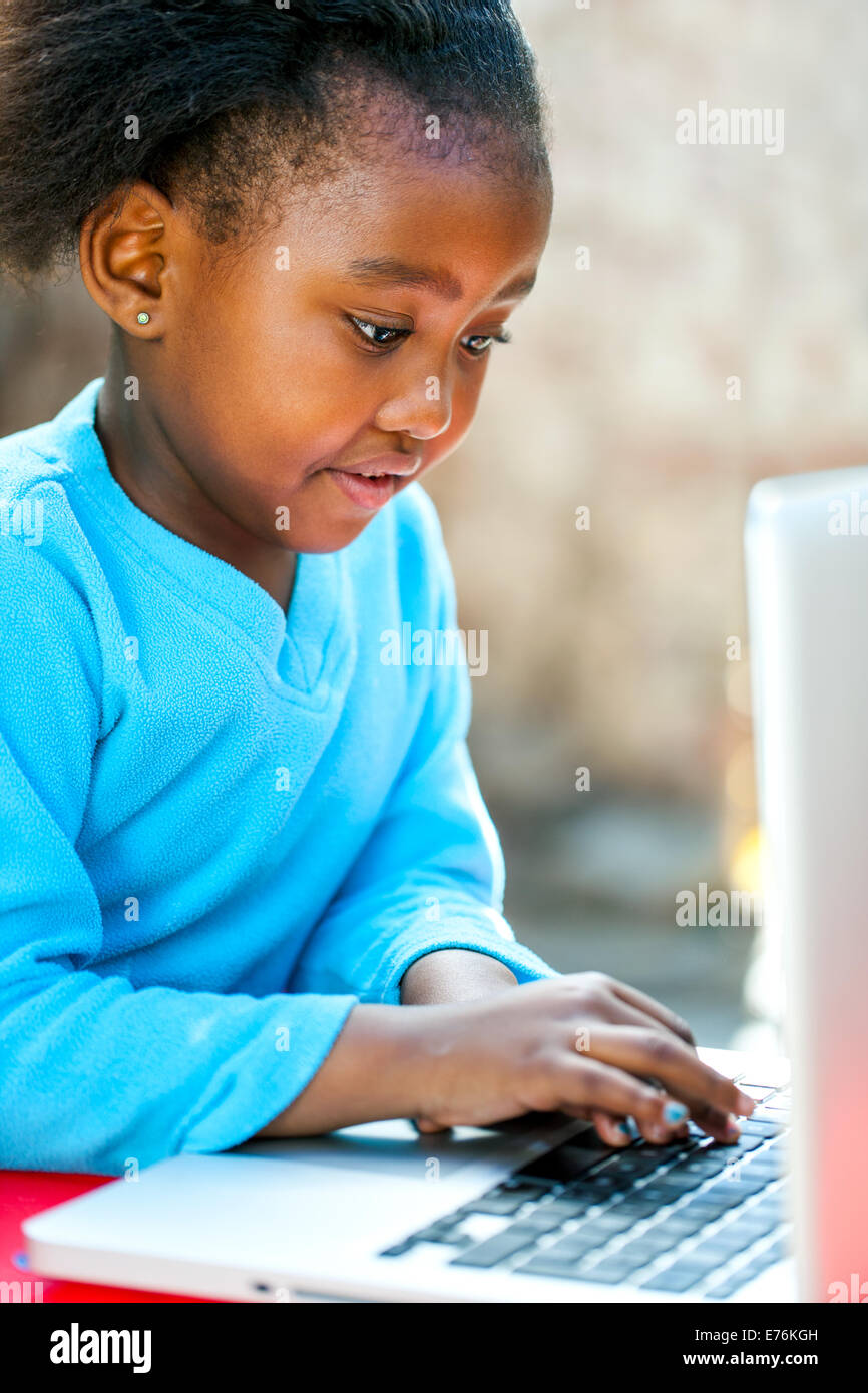 Afrikanische Mädchen tippen und Navigieren auf Laptop im Freien. Stockfoto