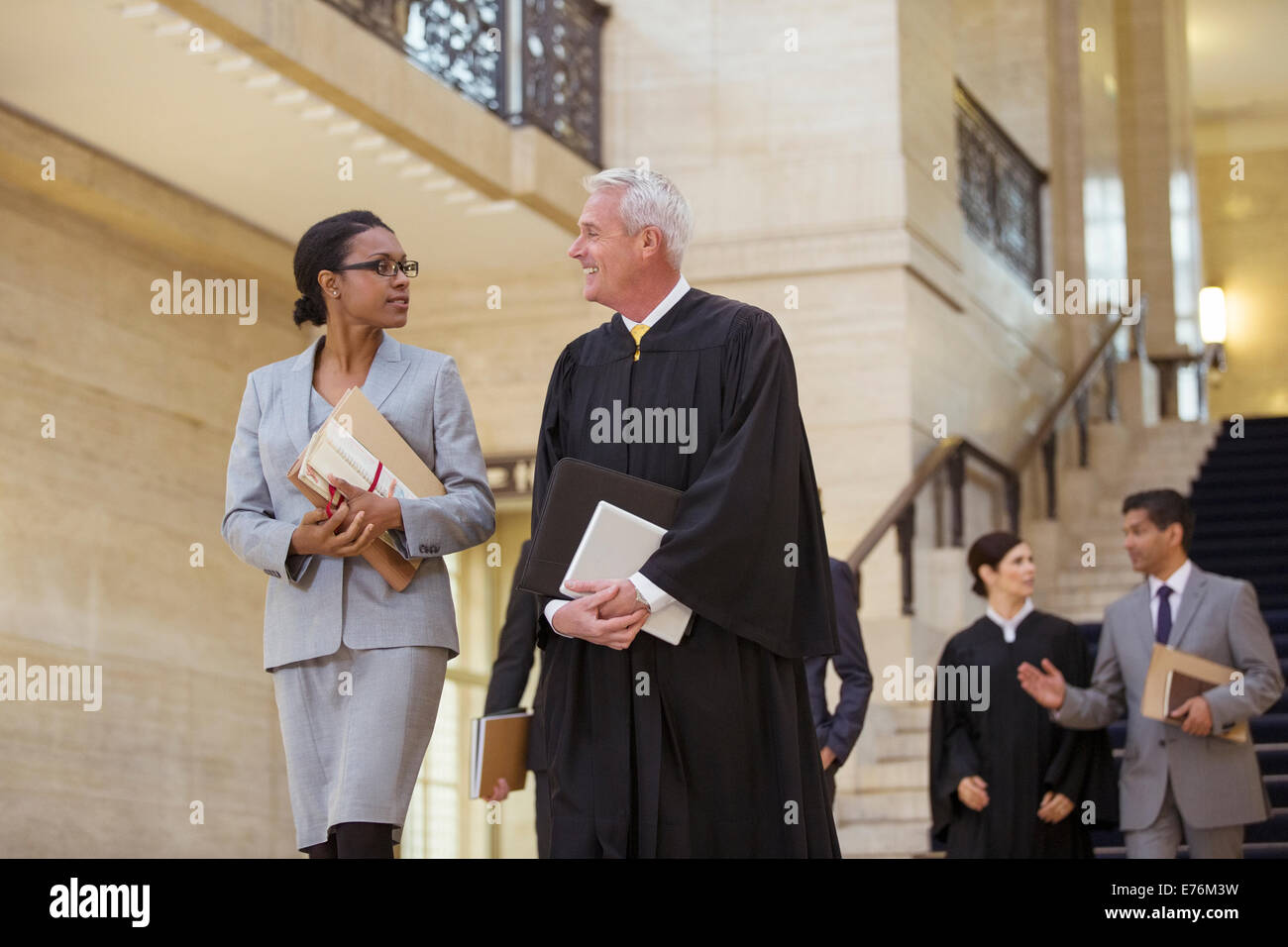 Richter und Anwalt zu Fuß durch Gerichtsgebäude zusammen Stockfoto