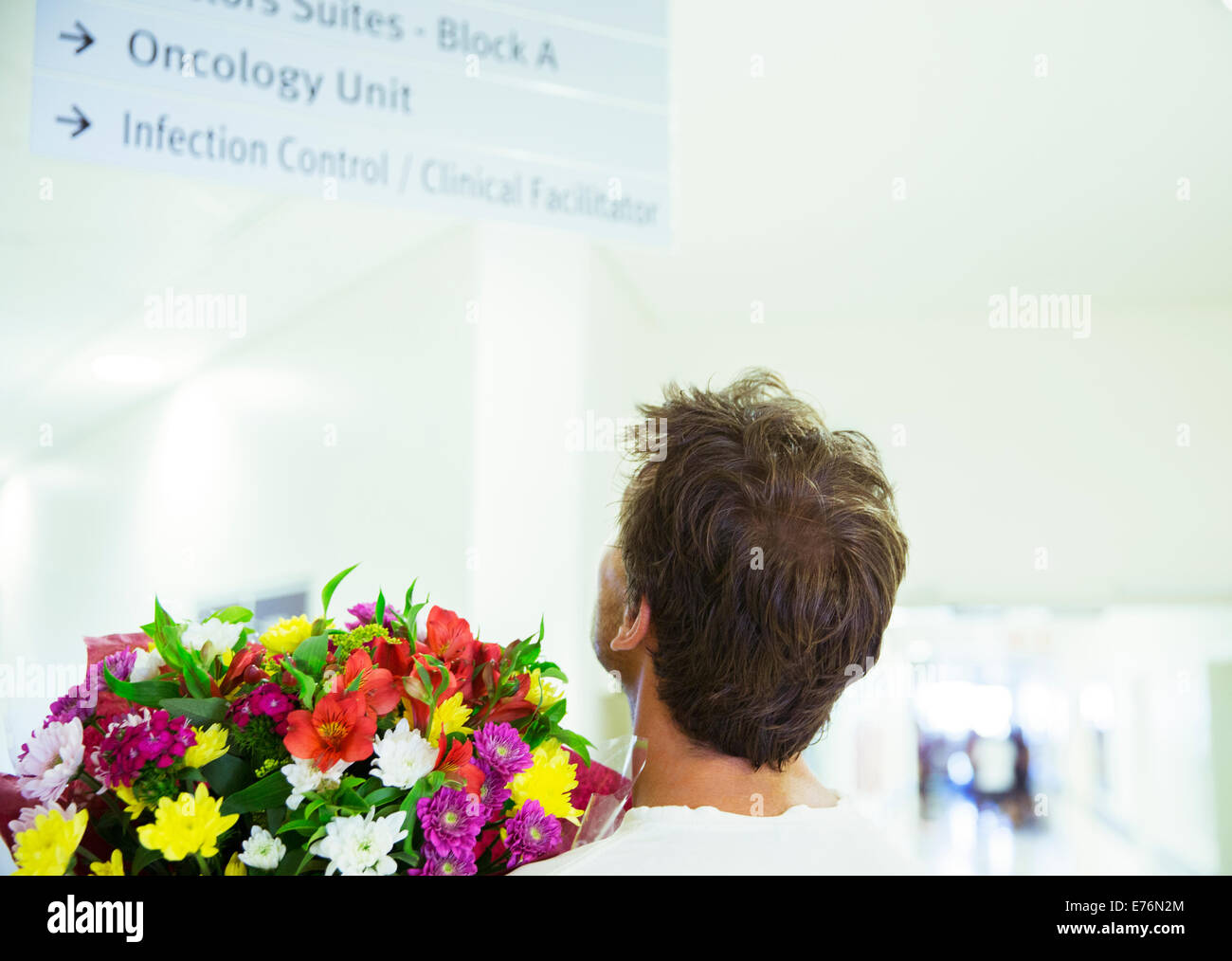 Mann mit Blumenstrauß im Krankenhaus Stockfoto