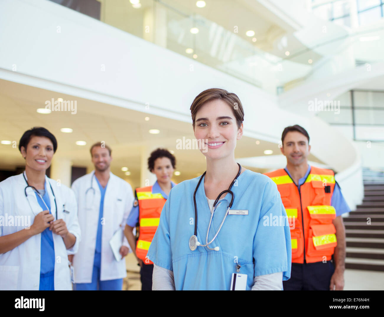 Ärzte, Krankenschwestern und Sanitäter, die lächelnd im Krankenhaus Stockfoto