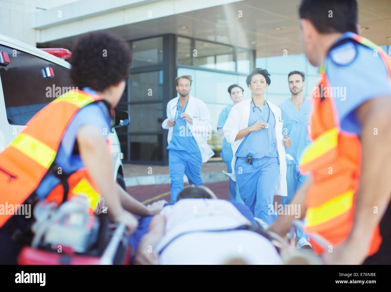 Ärzte und Krankenschwestern hetzen, um Patienten auf Krankenwagen Bahre Stockfoto