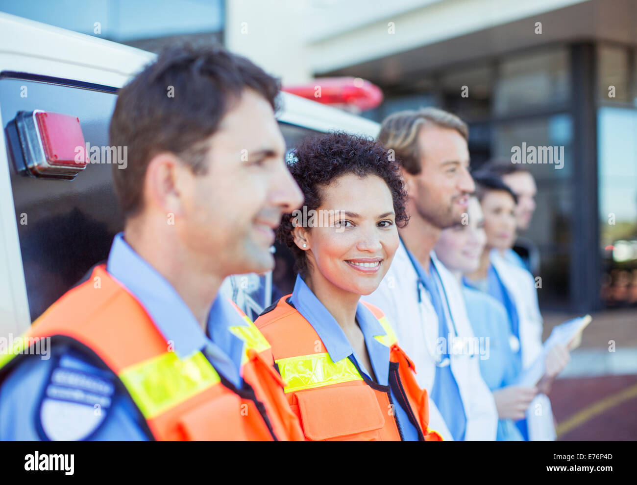 Sanitäter, Ärzte und Krankenschwestern mit dem Krankenwagen lächelnd Stockfoto