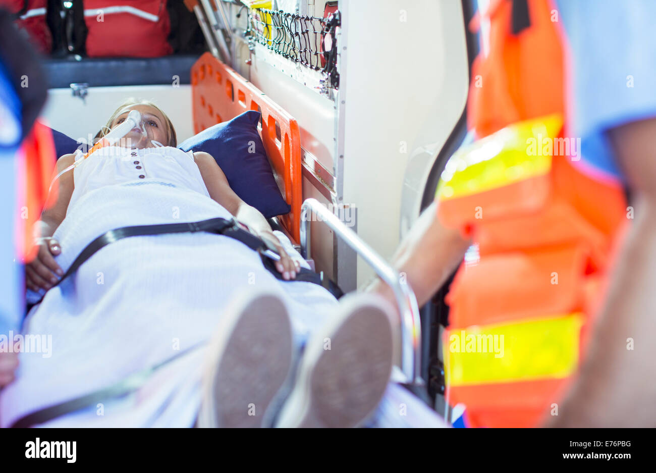 Rettungssanitäter Prüfung Patienten auf Bahre in Ambulanz Stockfoto