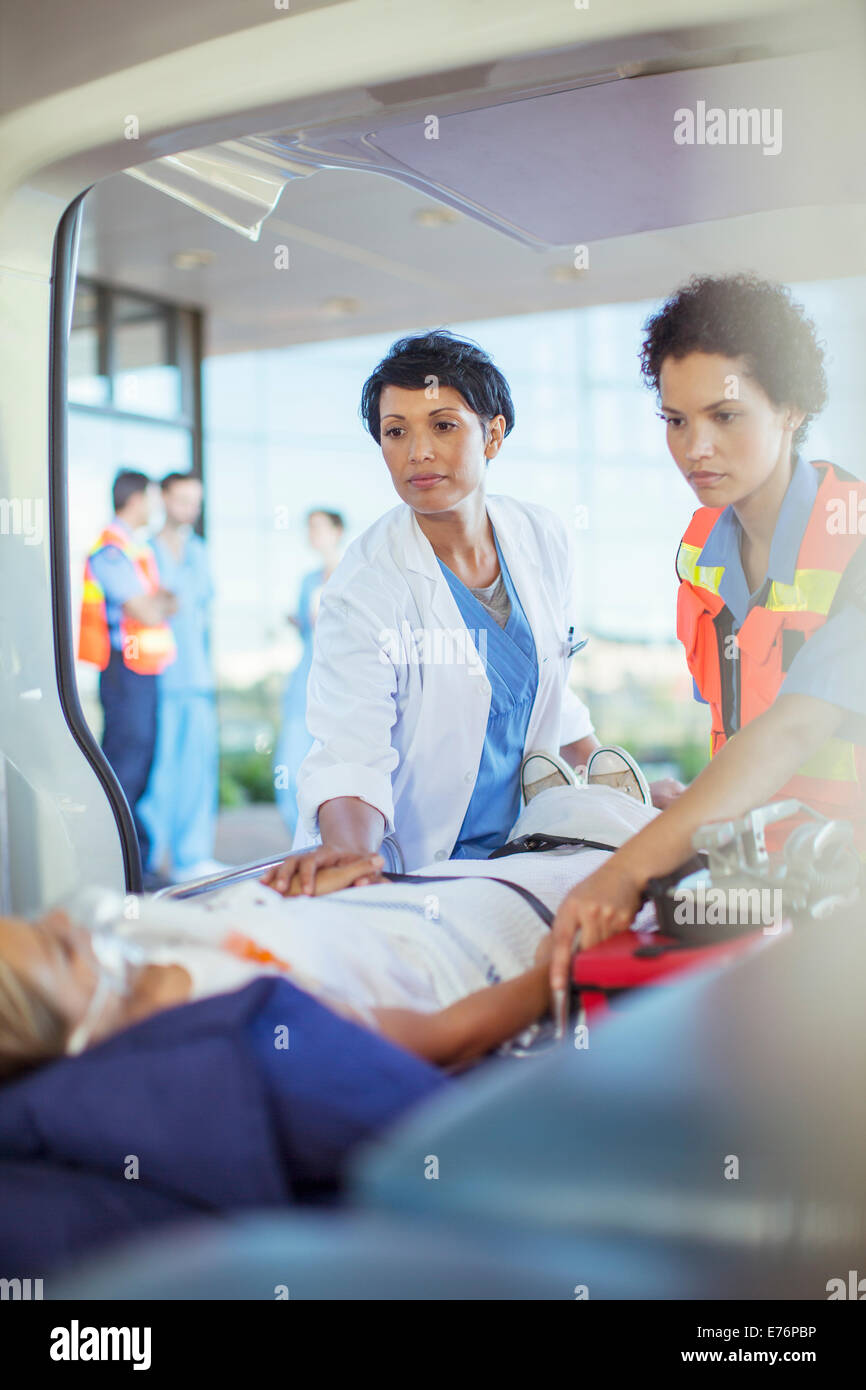 Arzt und Sanitäter untersuchen Patienten in Ambulanz Stockfoto