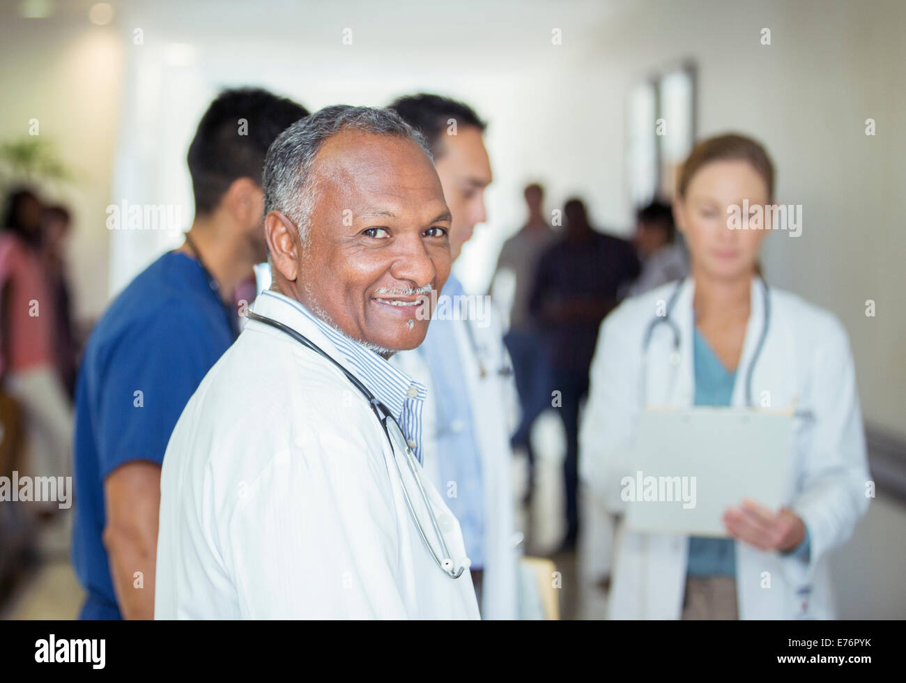 Arzt im Krankenhaus Flur lächelnd Stockfoto