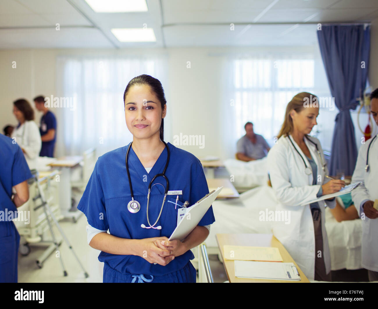 Krankenschwester, die lächelnd im Krankenzimmer Stockfoto
