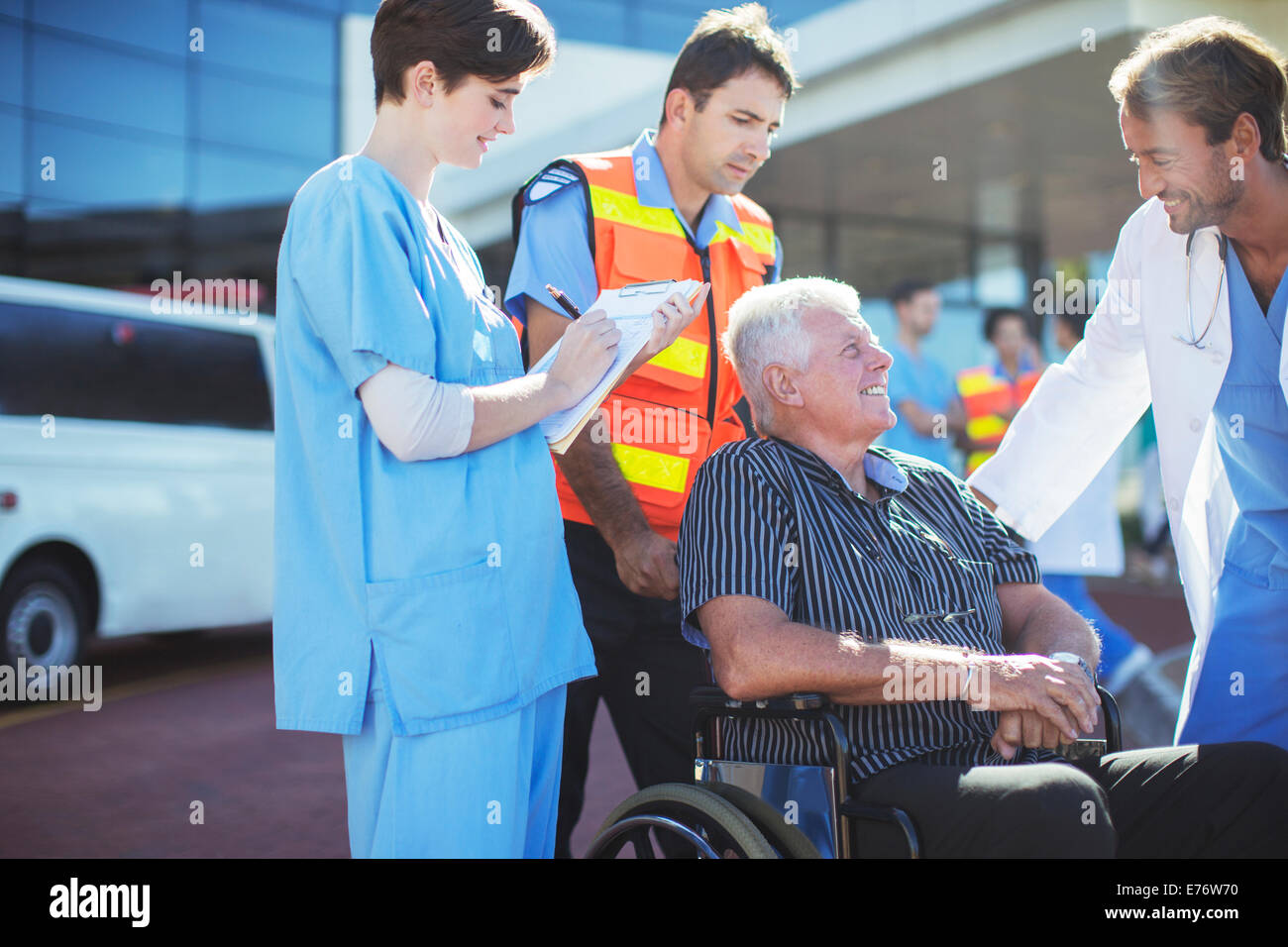 Arzt, Krankenschwester und Sanitäter im Gespräch mit Patienten außerhalb der Klinik Stockfoto