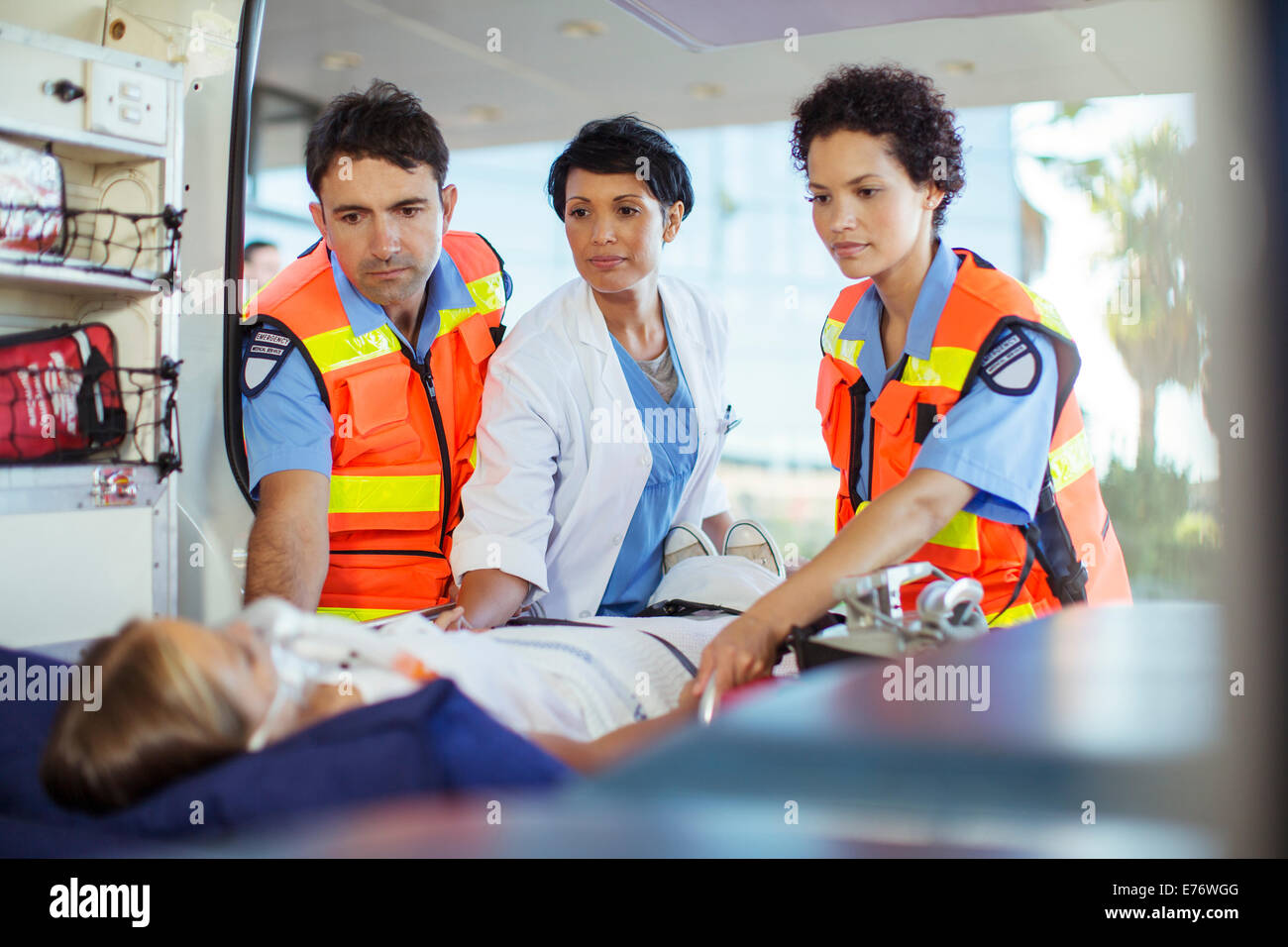 Arzt und Sanitäter untersuchen Patienten in Ambulanz Stockfoto