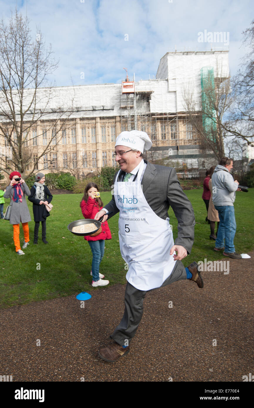 Journalisten und MPs konkurrieren um Charity bei der jährlichen parlamentarischen Pfannkuchen Rennen im Victoria Tower Gardens im Zentrum von London.  Mitwirkende: Martin Horwood wo: London, Vereinigtes Königreich bei: 4. März 2014 Stockfoto