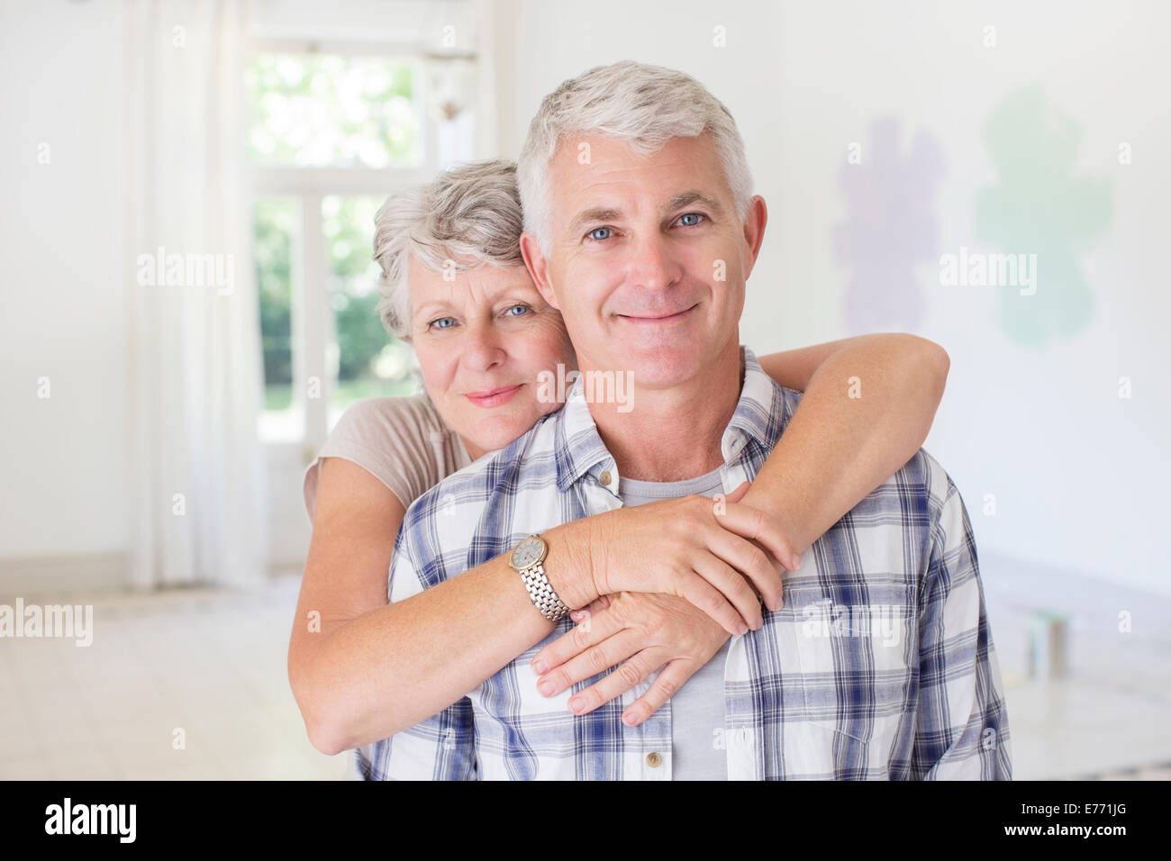 Älteres Ehepaar umarmt im Wohnraum Stockfoto
