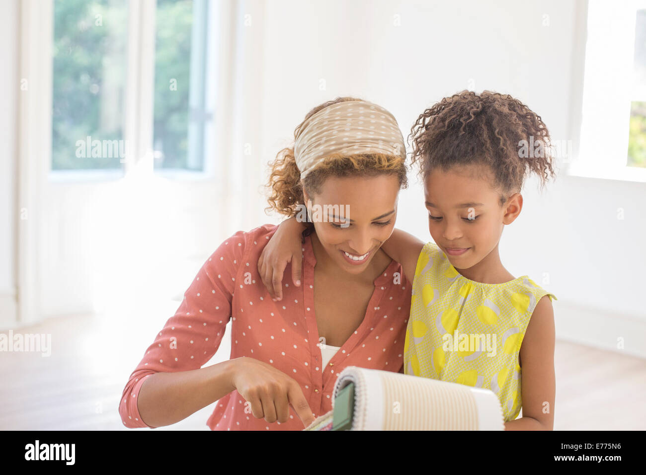 Mutter und Tochter miteinander durch Stoffproben zu suchen Stockfoto