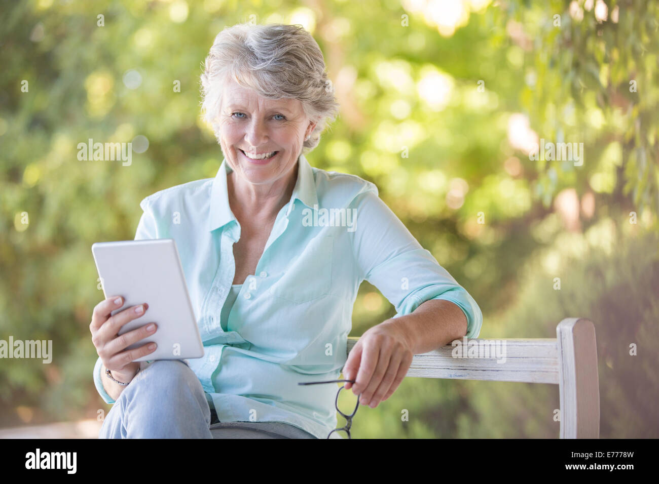 Ältere Frau mit digitalen Tablet im freien Stockfoto