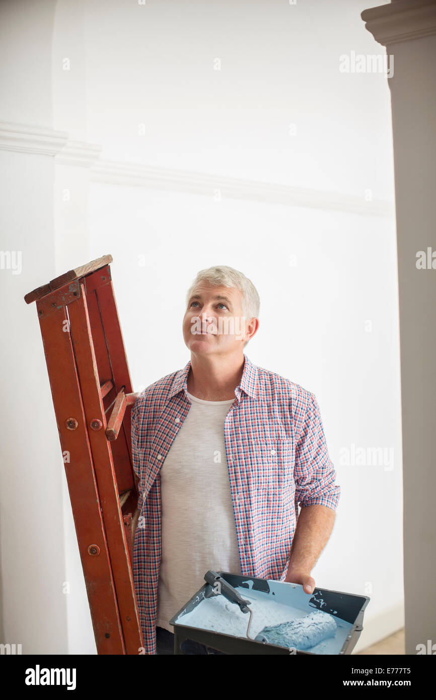 Mann mit Leiter und Farbe Tablett Stockfoto