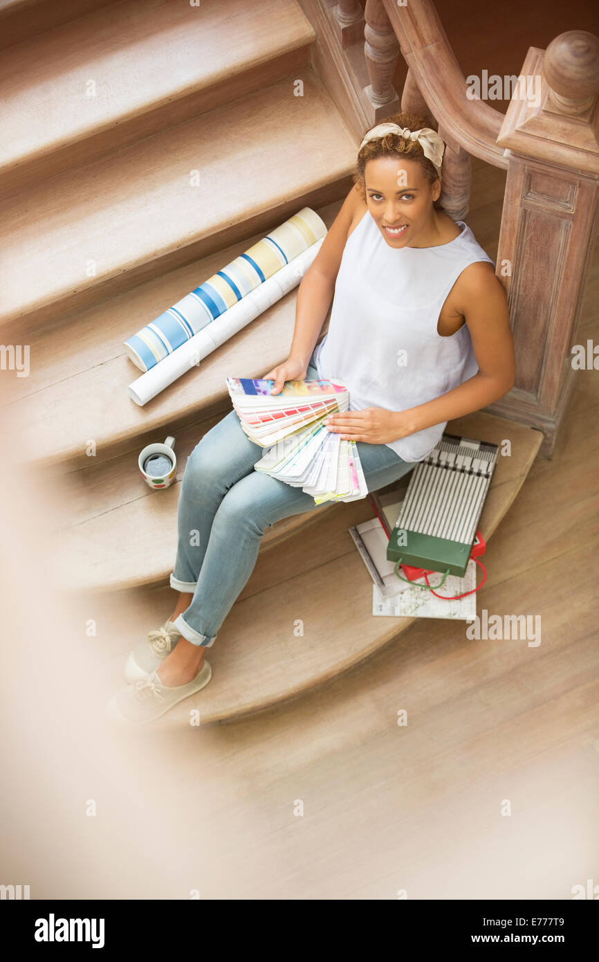 Frau sitzt auf der Treppe durchsehen Farbfelder Stockfoto