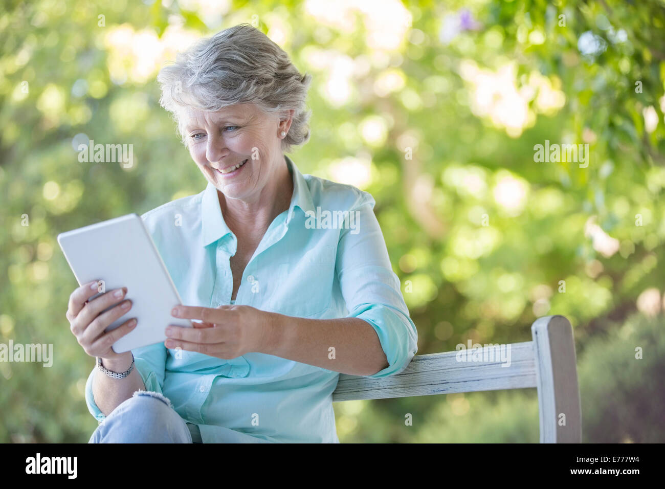 Ältere Frau mit digitalen Tablet im freien Stockfoto