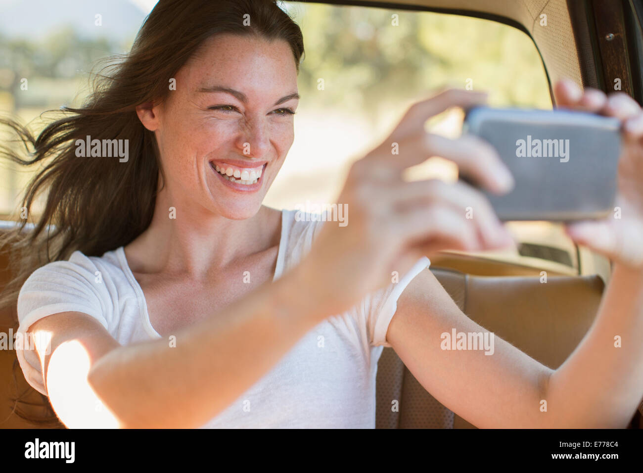 Frau Reiten im Auto unter Bild mit Handy Stockfoto